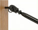 Close-up view of a black cable railing tensioner fitting securely installed into a wooden deck post, holding a taut stainless steel wire rope.