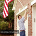 Woman displaying flag using wall mount flagpole bracket on house porch