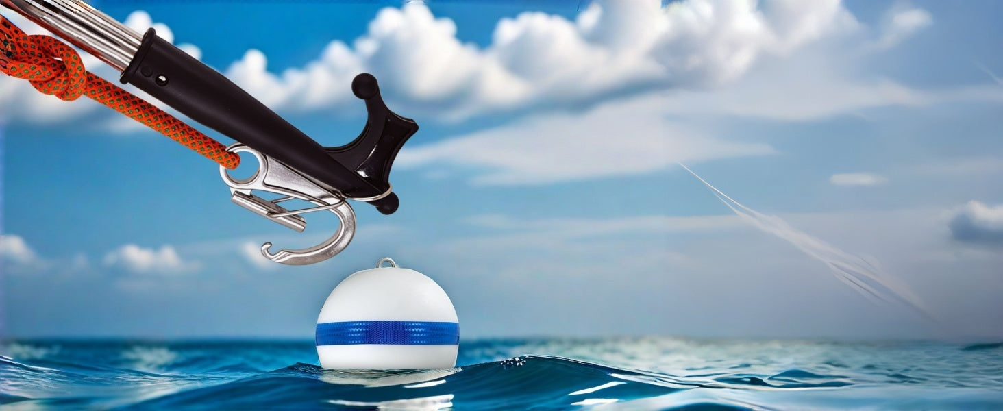 Action shot of a stainless steel remote buoy threader and quick-release mooring hook attached to a boat pole. Guided by an orange rope, the marine hardware reaches out to catch a white and blue mooring buoy floating in the clear blue ocean.